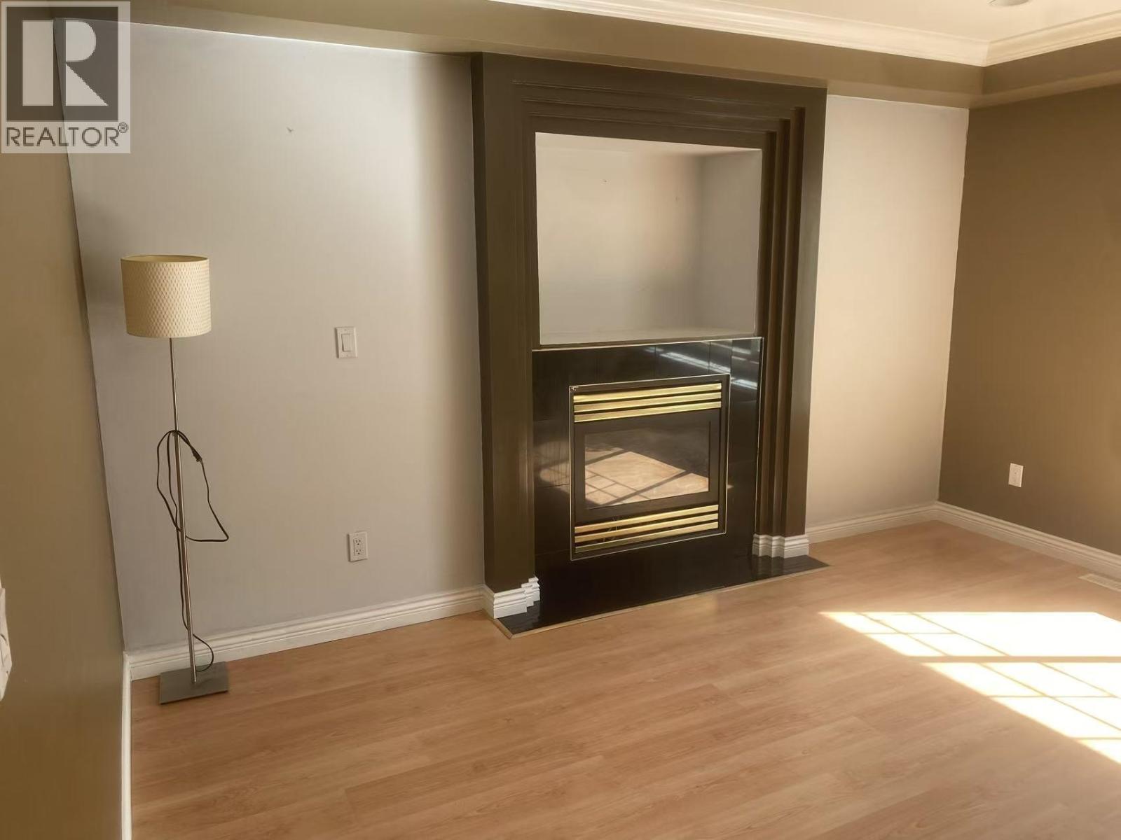 A living room with a fireplace and a lamp.