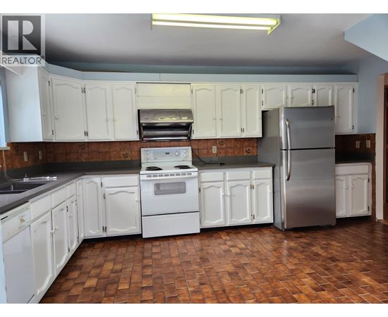 A kitchen with white cabinets and a tile floor.