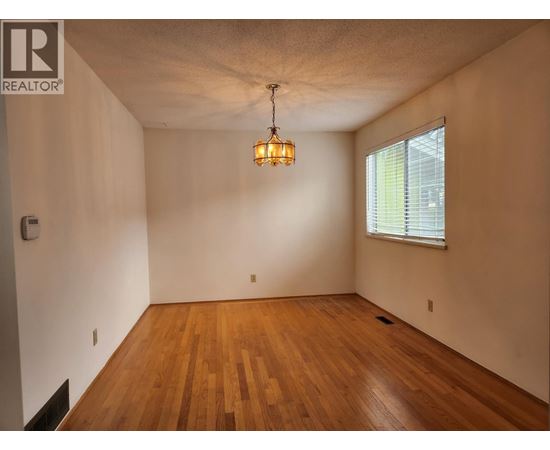 A room with wooden floors and a window with blinds.