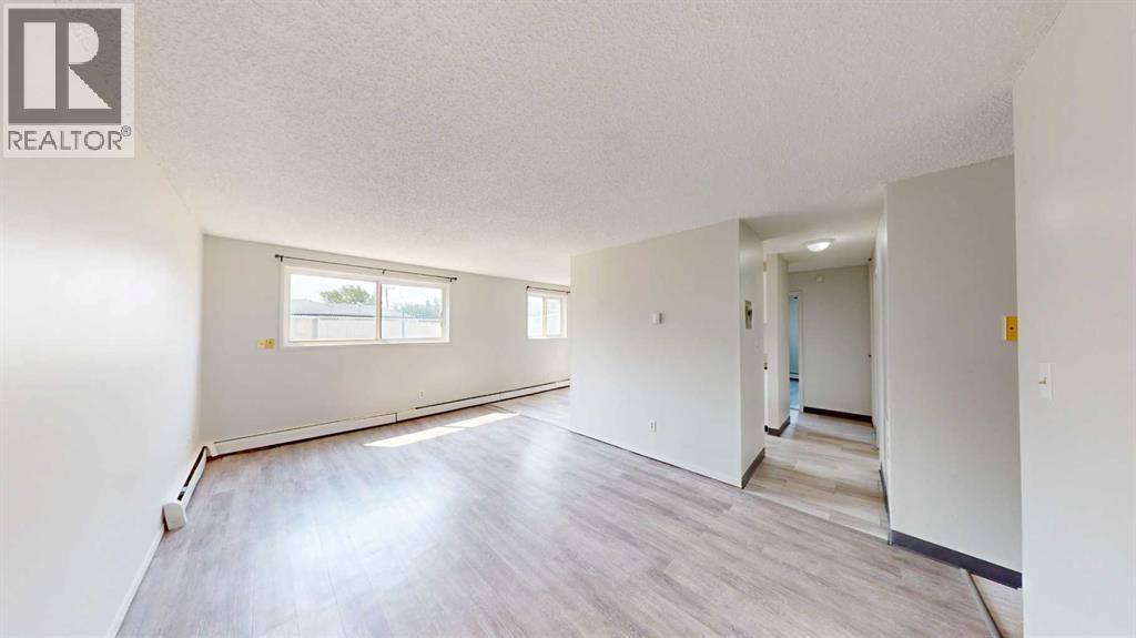 A spacious room with a window and a door leading to another room.