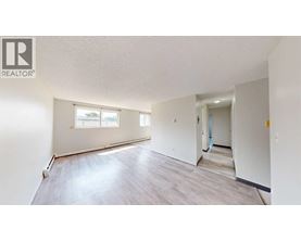 A spacious room with a window and a door leading to another room.