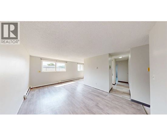 A spacious room with a window and a door leading to another room.