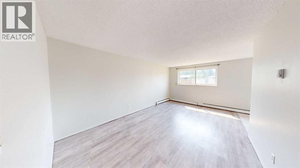 A room with a window and wooden flooring.