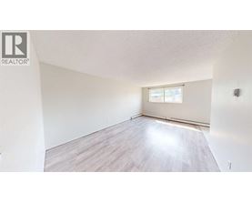 A room with a window and wooden flooring.
