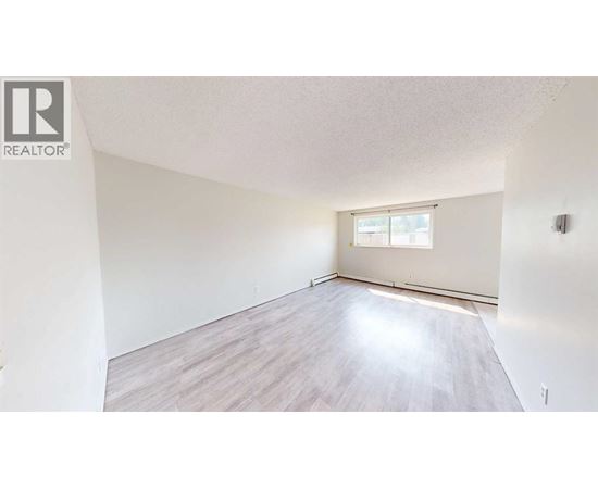 A room with a window and wooden flooring.