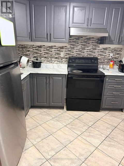 A kitchen with a black stove and refrigerator.