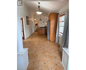 A spacious kitchen with wooden cabinets and a tiled floor.