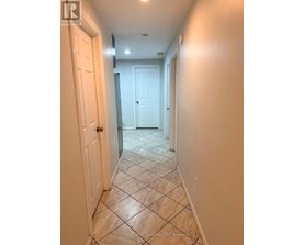 A hallway with tiled floors and white doors.