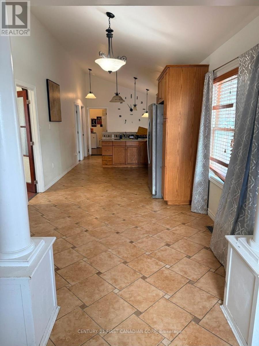 A spacious kitchen with wooden cabinets and a tiled floor.