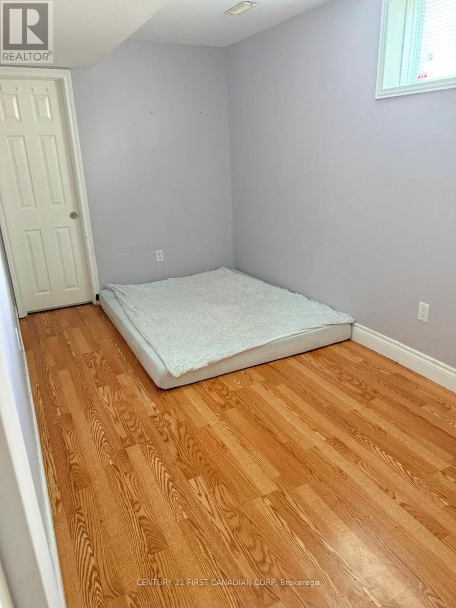A bedroom with a bed and wooden floors.