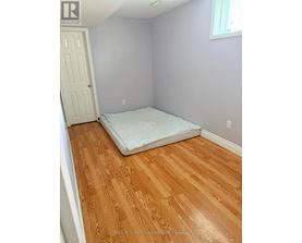 A bedroom with a bed and wooden floors.