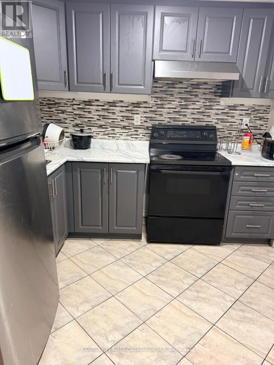 A kitchen with a black stove and refrigerator.