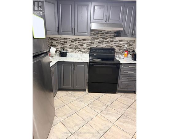 A kitchen with a black stove and refrigerator.