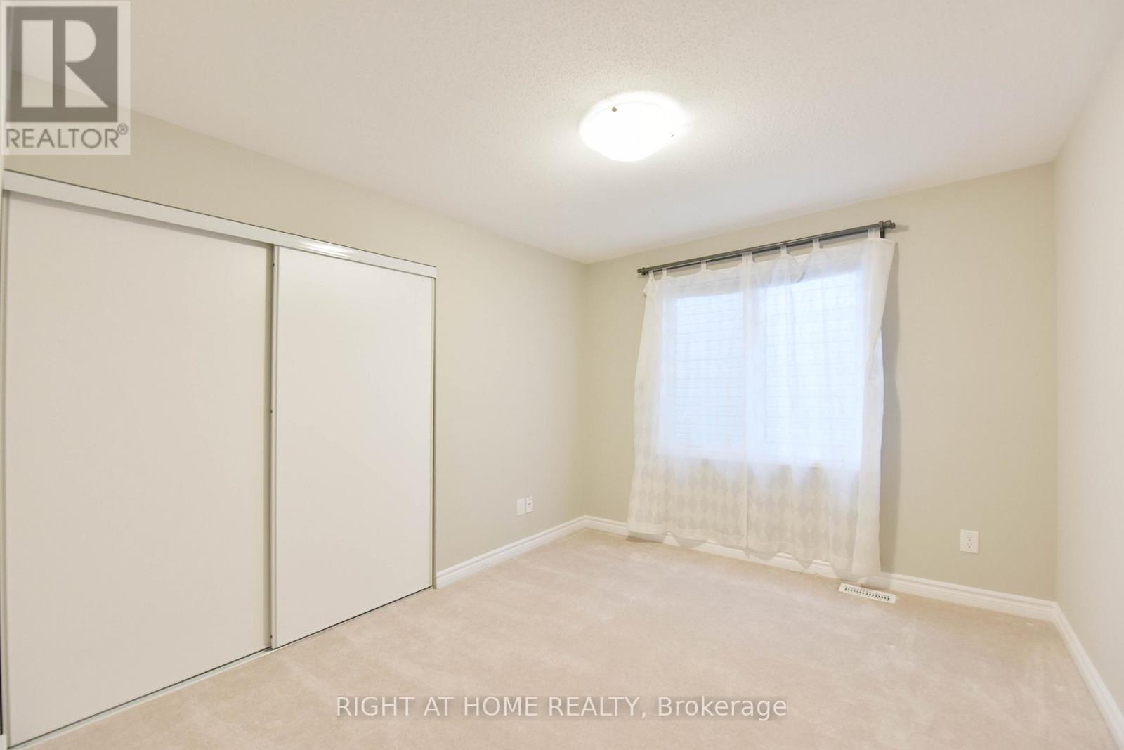 A bedroom with a sliding door and a window with curtains.