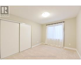 A bedroom with a sliding door and a window with curtains.