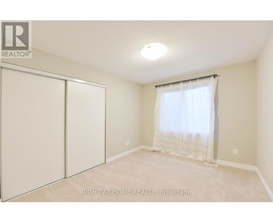 A bedroom with a sliding door and a window with curtains.
