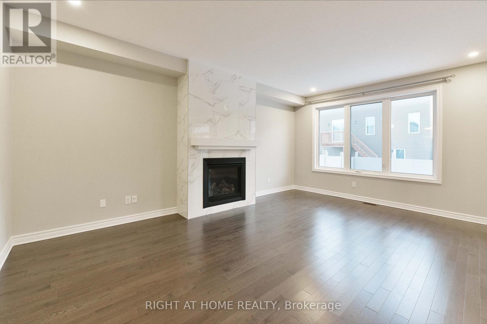 A spacious room with a fireplace and a large window.