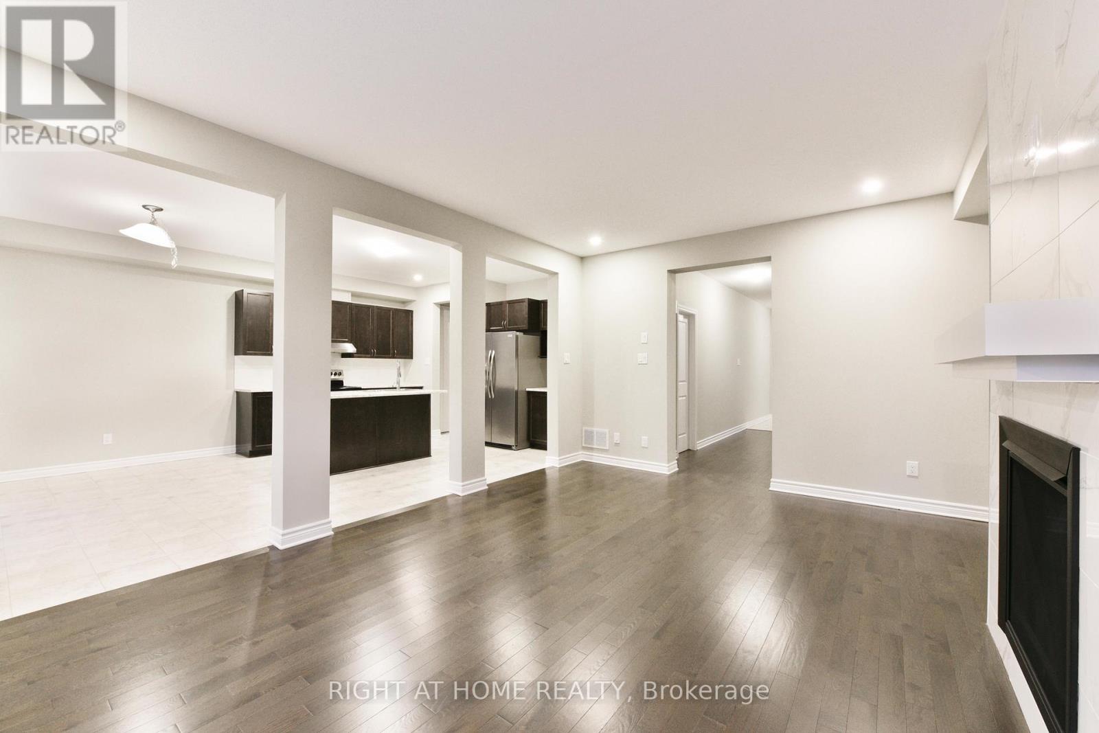 A spacious living room with a fireplace and hardwood floors.