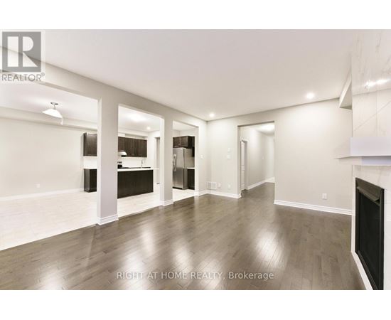 A spacious living room with a fireplace and hardwood floors.