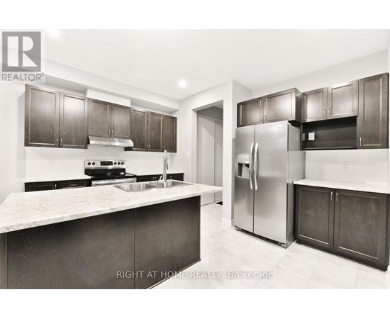 A modern kitchen with dark brown cabinets and a marble countertop.