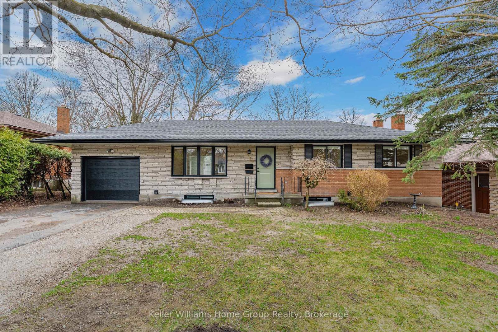 A house with a grey roof and a green door is for sale.