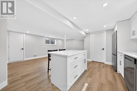 A kitchen with white cabinets and a wooden floor.