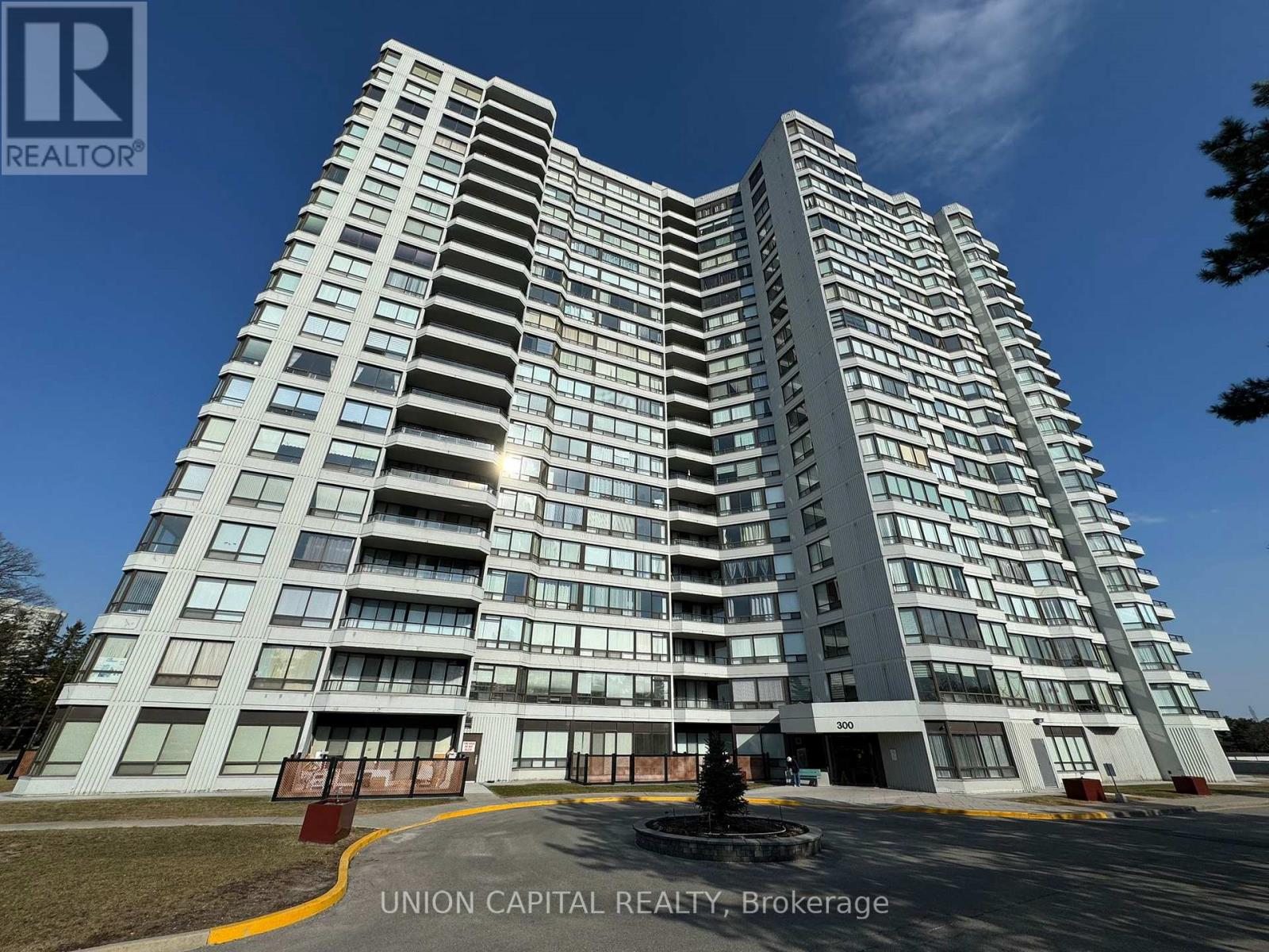 A tall residential building with a fountain in front.