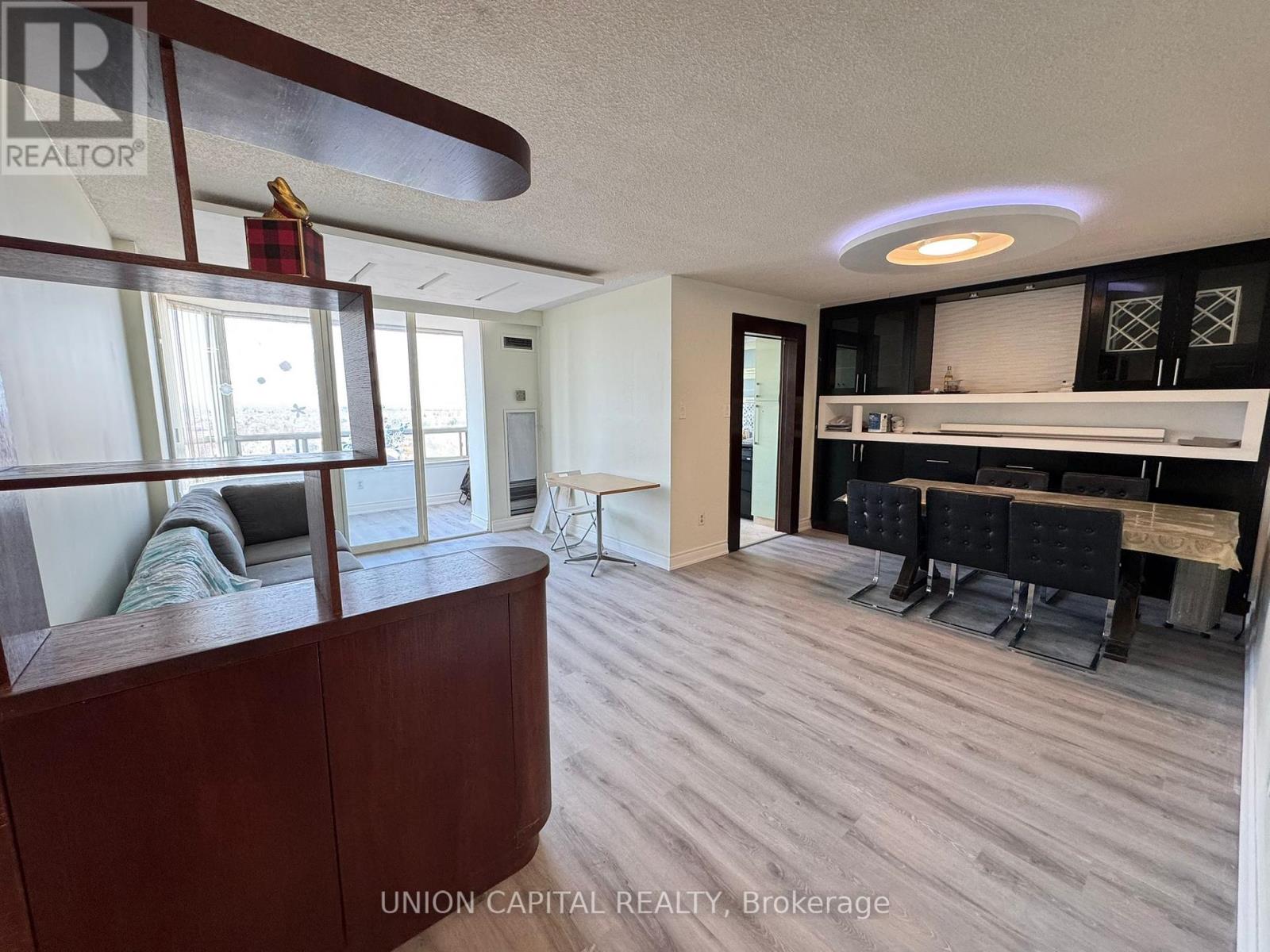 A living room with a couch, chairs, and a bar area.