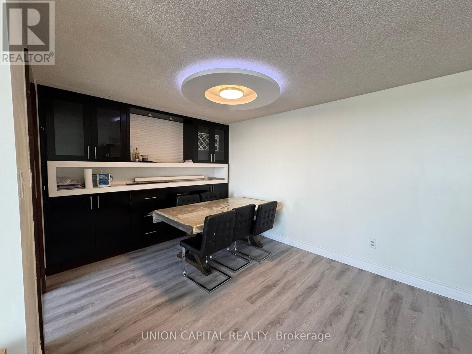 A dining area with a table and chairs in a room with wood flooring.