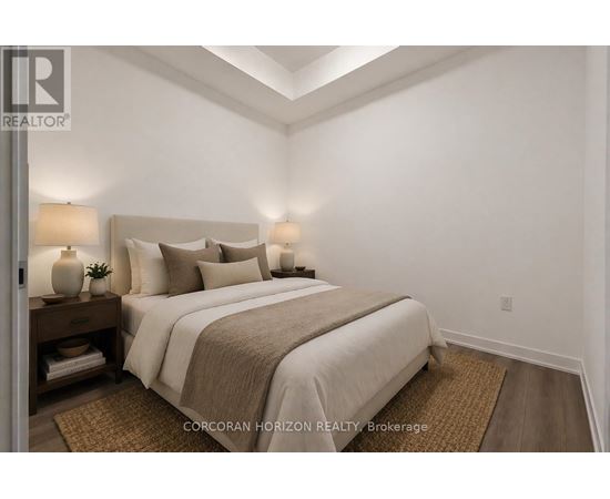 A bedroom with a large bed and two lamps on either side of the bed.