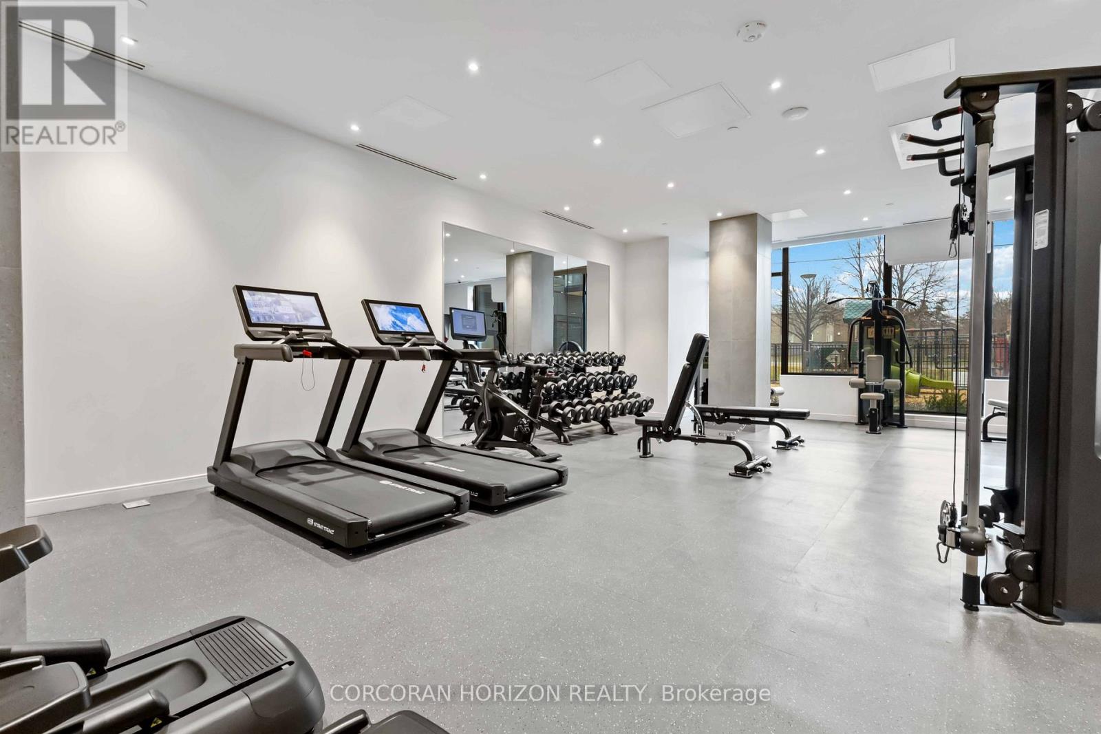 A gym with treadmills, exercise bikes, and weights.