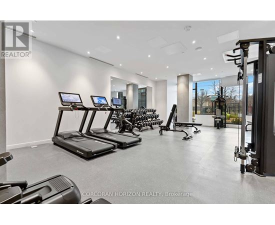 A gym with treadmills, exercise bikes, and weights.