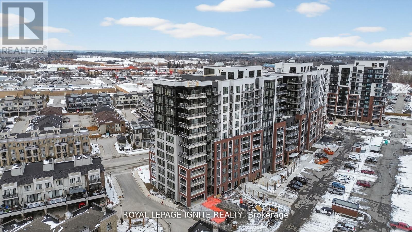 A cityscape with a mix of modern and older buildings, with a clear sky and some snow on the ground.