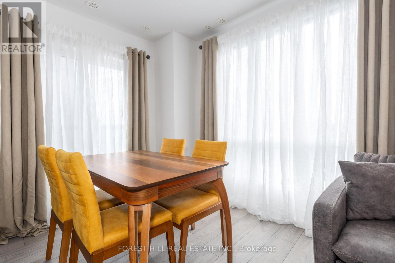 A dining room with a wooden table and chairs.