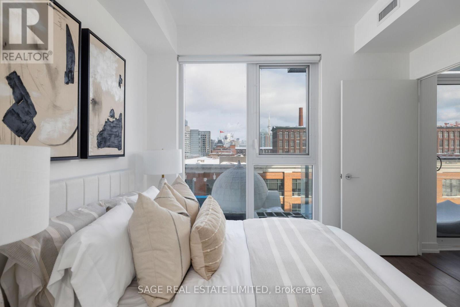 A bedroom with a large bed and a view of the city through the window.