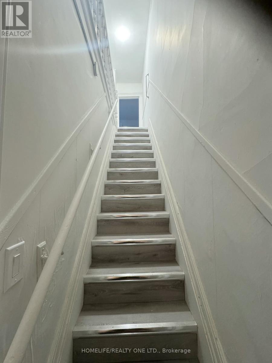 A staircase with wooden steps and white walls.