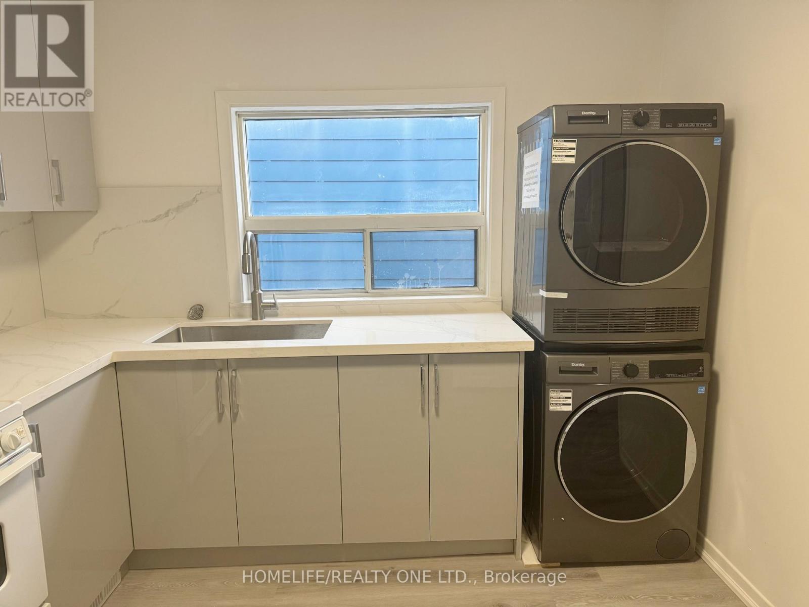 A laundry room with a washer and dryer stacked on top of each other.