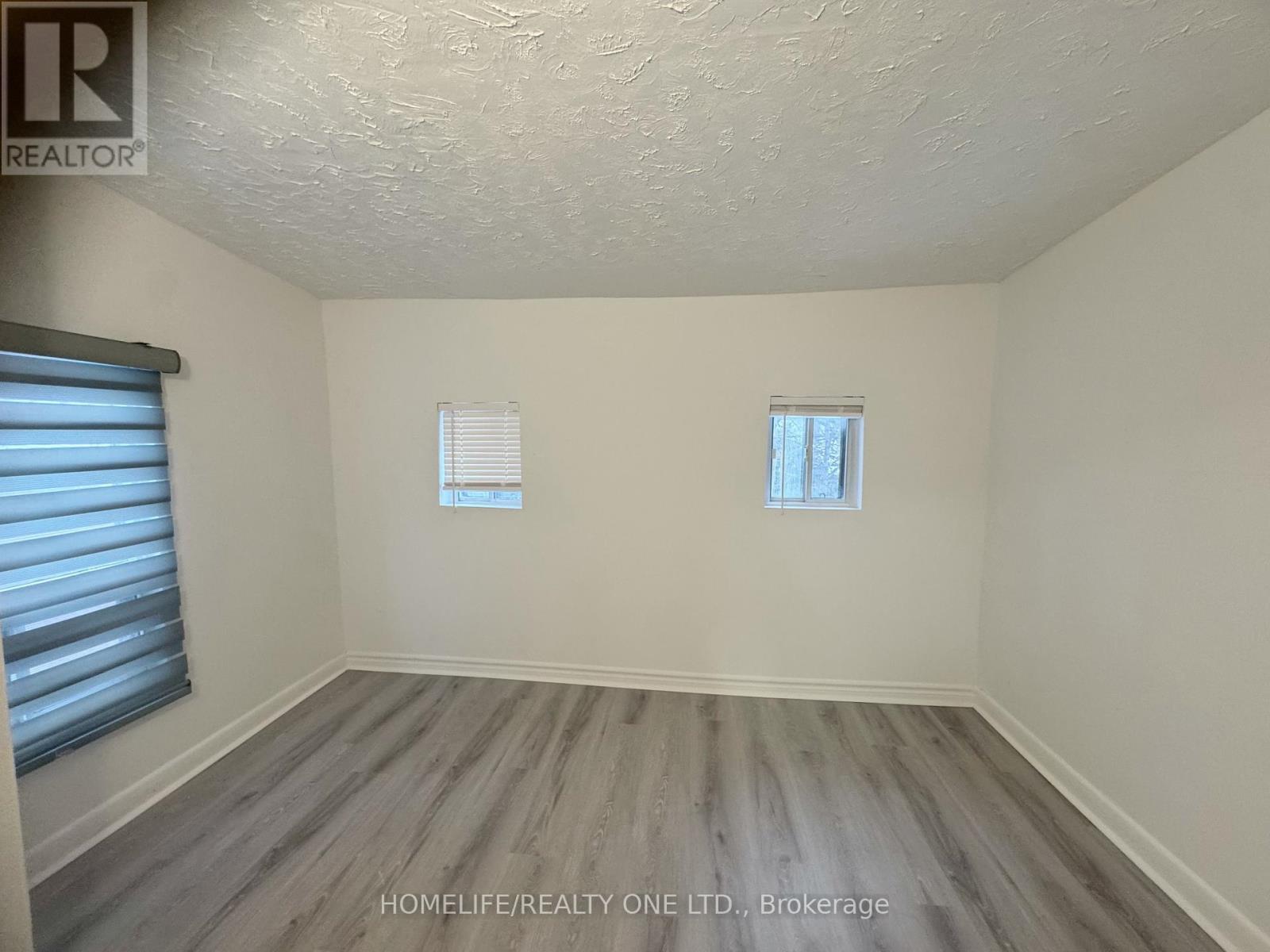 A room with a window and a wooden floor.