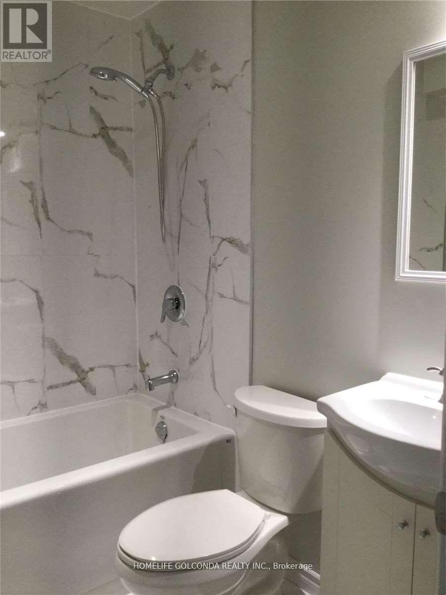 A white toilet sits in a bathroom with marble walls.