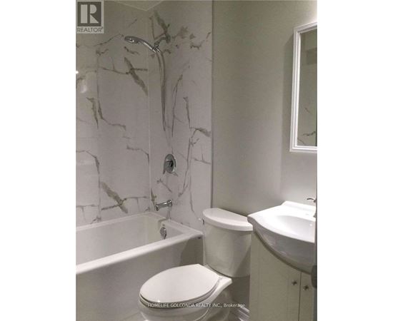A white toilet sits in a bathroom with marble walls.