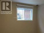 A window with blinds in a room with a Realtor sign on the wall.