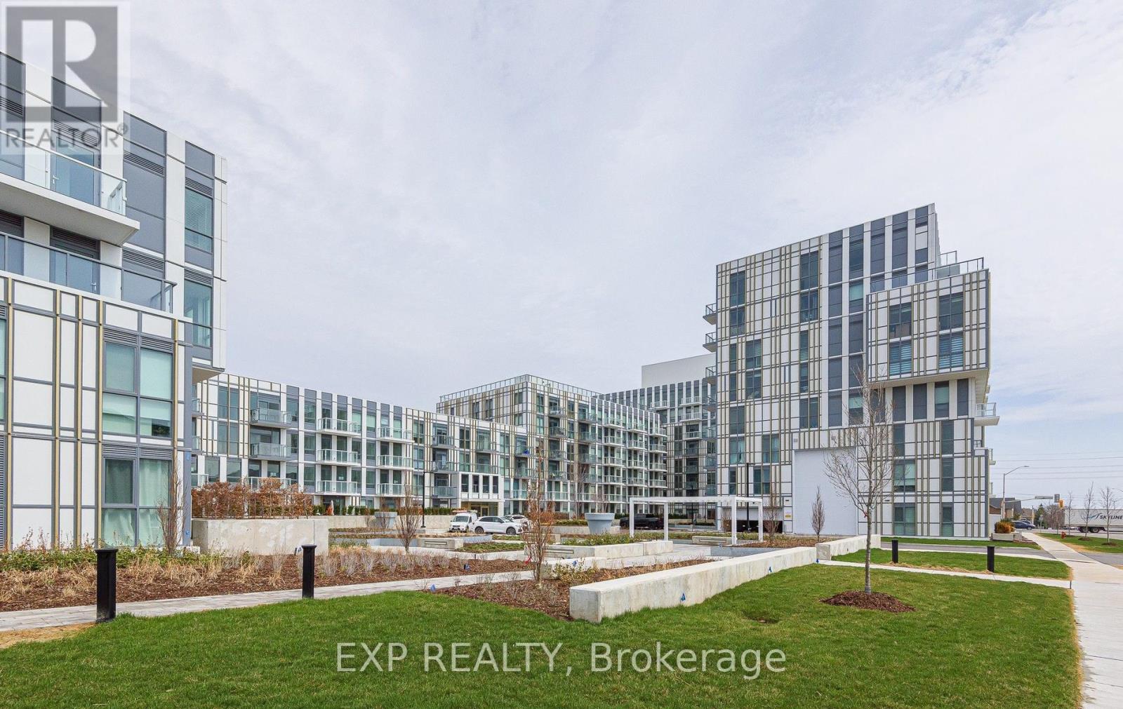 A modern building complex with the text EXP REALTY, Brokerage on the grassy area in front.