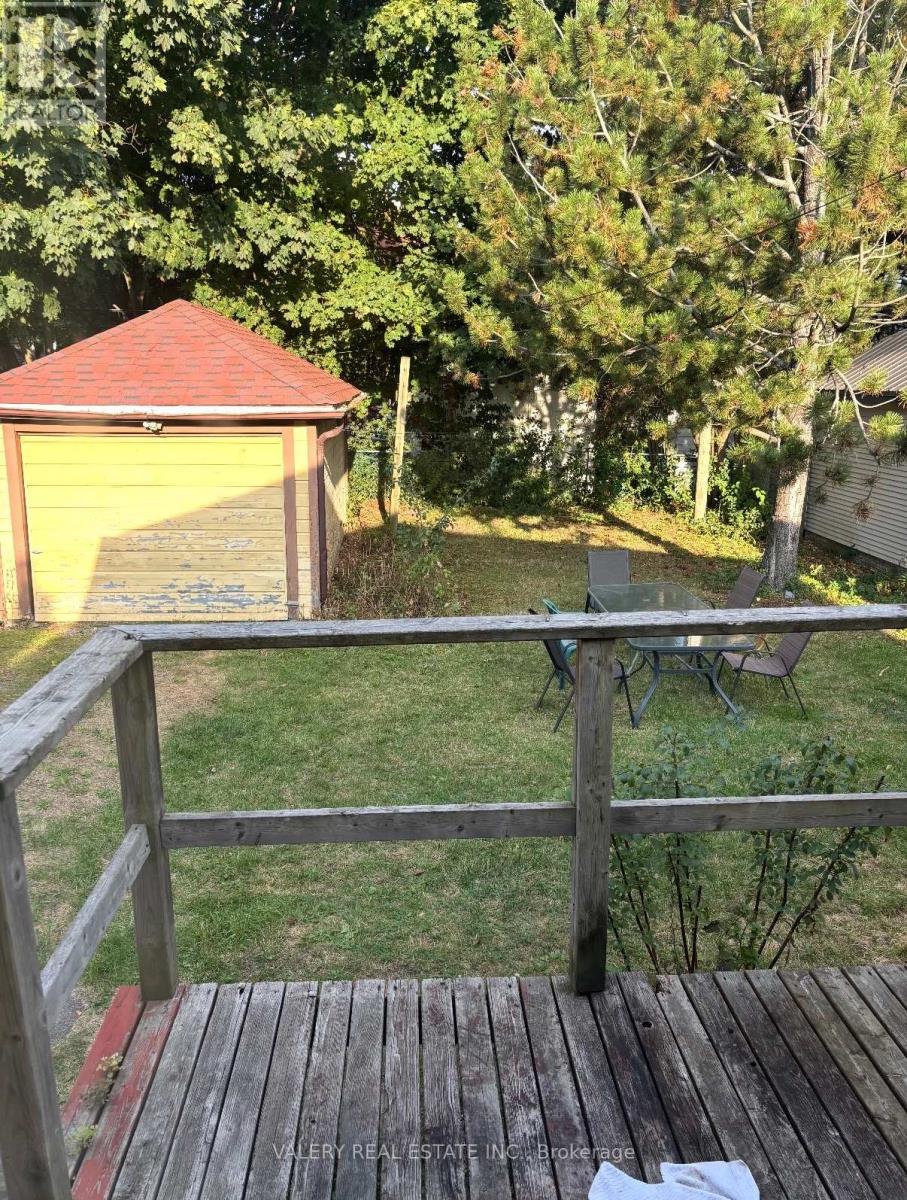A wooden deck with a table and chairs overlooking a backyard.