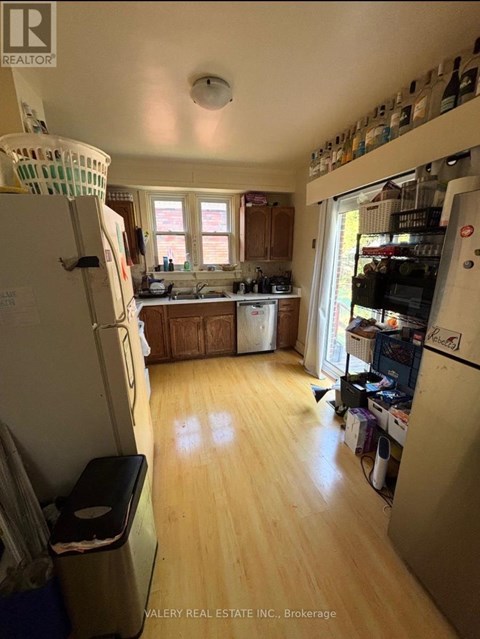 A kitchen with wooden floors and a white refrigerator.