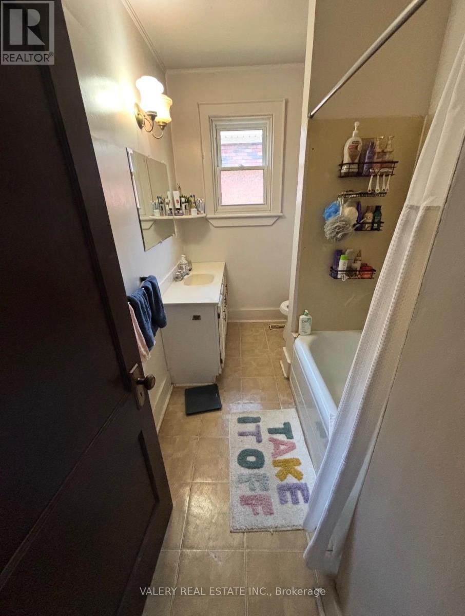 A bathroom with a towel hanging on the door and a window.