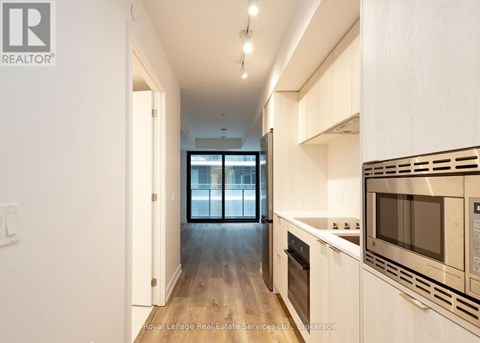 A modern kitchen with white cabinets and stainless steel appliances.