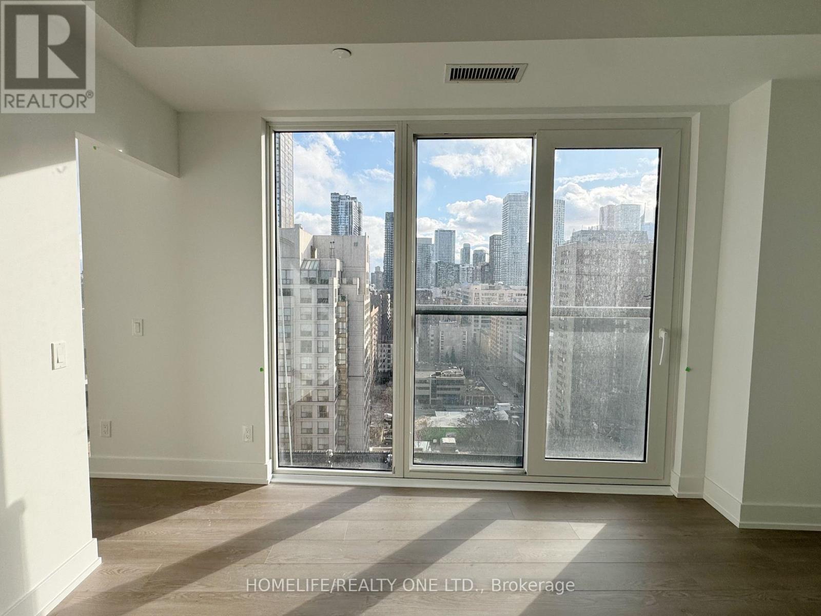 A room with a view of the city through large windows.