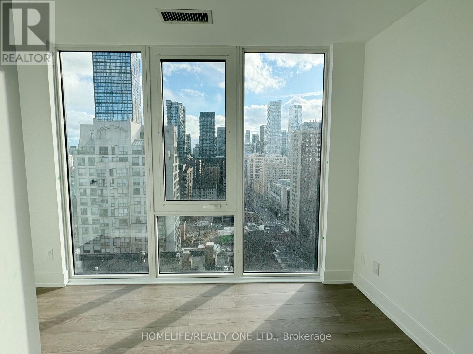A room with a view of the city through a large window.