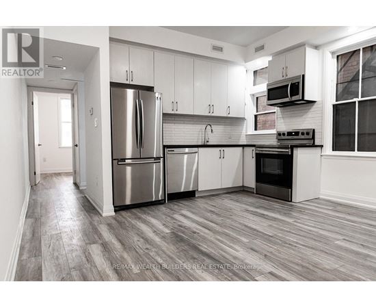 A modern kitchen with stainless steel appliances and white cabinets.