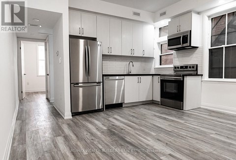 A modern kitchen with stainless steel appliances and white cabinets.